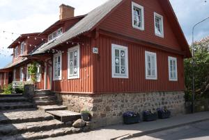 a red house with stairs in front of it at Trakai Old town Apartment in Trakai