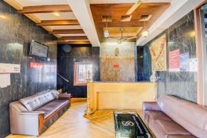 uma sala de estar com sofás de couro e um bar em Sivamurugan Hotels em Kumbakonam