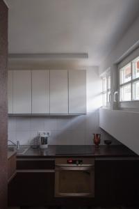 a kitchen with white cabinets and a black counter top at Trakai Old town Apartment in Trakai +32 photos