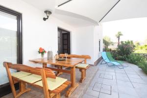 a patio with a wooden table and chairs at Apartment Adrijana in Vrbnik