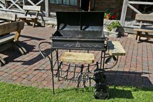 a grill sitting on a stand in the grass at Poilsis pas Joną in Plateliai