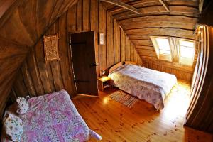 a bedroom in a wooden cabin with a bed and a window at Poilsis pas Joną in Plateliai
