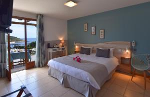 a bedroom with a large bed with a view of the ocean at Hotel Palazzu & SPA - Adult Only in Galeria