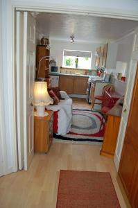 a small room with a bed and a kitchen at The Willows in Tintagel