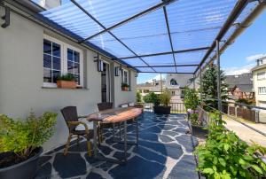 a patio with a glass roof over a table and chairs at Fewo " Schmiede " Innenstadt, ruhige Lage, große Terrasse, Wlan inkl. in Rüdesheim am Rhein +8 photos