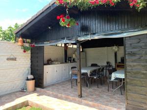 a patio with a table and chairs under an umbrella at Vila Ann in Eforie Nord