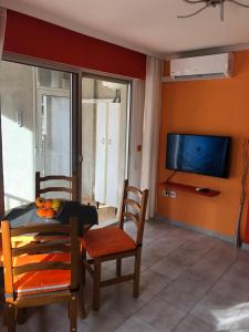 salon ze stołem, krzesłami i telewizorem w obiekcie Gallud Apartament w mieście Torrevieja