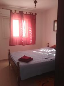 a bedroom with a bed with red curtains and a window at Apartment for relaxing and for health in Haifa