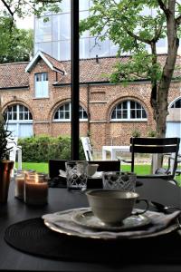einen Tisch mit einem Teller Essen auf einem Tisch mit einem Fenster in der Unterkunft Broel4 in Kortrijk