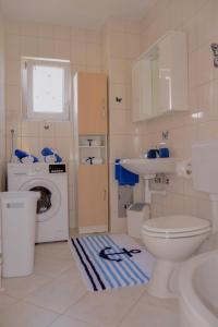 ein Badezimmer mit einem Waschbecken und einer Waschmaschine in der Unterkunft City roof top Apartment Cambi in Kaštela