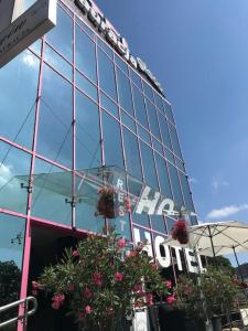 un bâtiment en verre avec des fleurs devant lui dans l'établissement Hotel & Restauracja Glass, à Radom