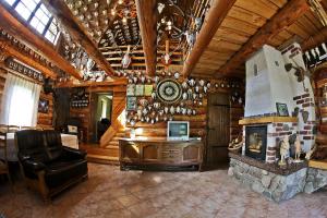 a living room with a fireplace in a log cabin at Poilsis pas Joną in Plateliai