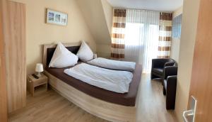 ein Schlafzimmer mit einem Bett und einem Stuhl in der Unterkunft zum weißen Ross in Limburg an der Lahn