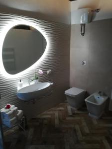 W łazience znajduje się umywalka, toaleta i lustro. w obiekcie Holiday Homes - mini spa - Nemi (Roma) w mieście Nemi
