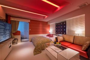 千葉市にあるHOTEL W-AVANZA-W GROUP HOTELS and RESORTS-のベッド、ソファ、テレビが備わる客室です。