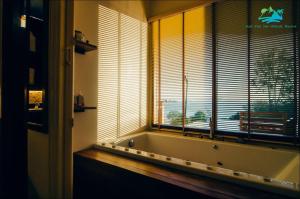 a bath tub in a bathroom with a window at Koh Yao Yai Hillside Resort in Ko Yao Yai