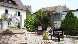einen Garten mit Stühlen und Blumen in einem Haus in der Unterkunft Mönchgut Boddenblick Wohnung 1 in Groß Zicker