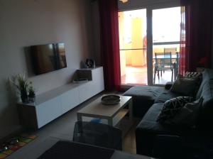 a living room with a couch and a tv at Las Islas de Terrazas de la torre in Roldán