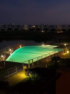 una gran piscina de agua verde por la noche en Las Islas de Terrazas de la torre en Roldán