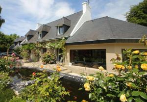 a house with a pond in front of it at La maison de l'Odet in Gouesnach