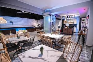 a restaurant with tables and chairs and a swimming pool at Retro luxury rooms in Olympiaki Akti