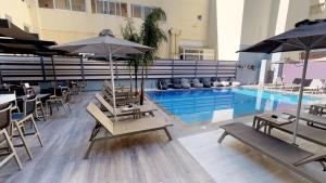 a pool with chairs and umbrellas in a building at Medusa Apartments in Rethymno Town