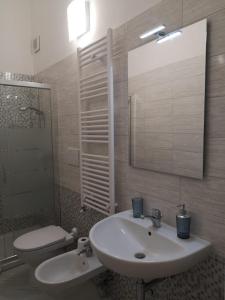 a bathroom with a sink and a toilet and a mirror at Casa Midori in Lecce +32 photos