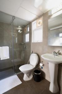 a bathroom with a toilet and a sink and a shower at Crest Executive Suites, Whitefield in Bengaluru