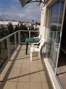 d'un balcon avec une table verte et des chaises blanches. dans l'établissement Joans place, à Velddrif