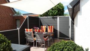 Un patio con mesa y sillas y una valla. en Ferienwohnung Stadt- und Hafennähe, en Fehmarn
