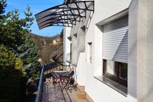 - un balcon avec une table et des chaises sur le côté du bâtiment dans l'établissement Alma Apartman, à Salgótarján