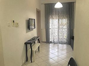 una stanza con tavolo e finestra con pianoforte di Alex Flat a Néoi Epivátai