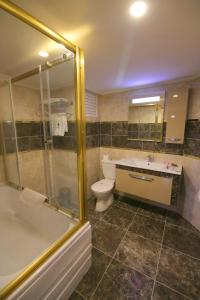 a bathroom with a shower and a toilet and a sink at Aykut Palace Otel in İskenderun