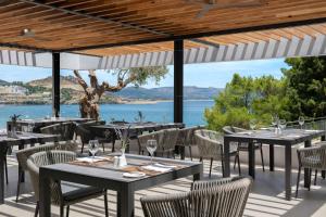 un ristorante con tavoli e sedie e vista sull'acqua di Lindos Mare, Seaside Hotel a Líndos