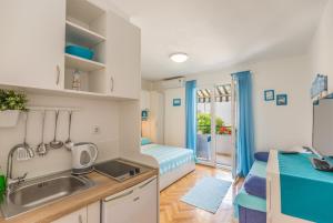 a kitchen with a sink and a bedroom with a bed at Apartmani Marko in Tučepi