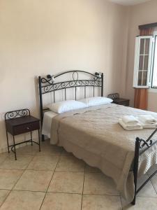 a bedroom with a large bed and two night stands at Myrto Apartments in Kálamos Kythira