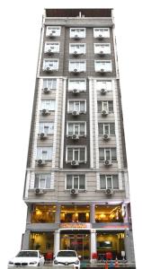 リゼにあるCmr Aydogan Hotelの車が目の前に停まった高い建物