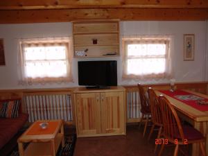 Una sala de estar con un televisor y una mesa con sillas. en Apartments Lana, en Bled
