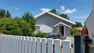 a white fence in front of a white house at L Escapade Médocaine Guest Room with Private Driver in Le Taillan-Médoc