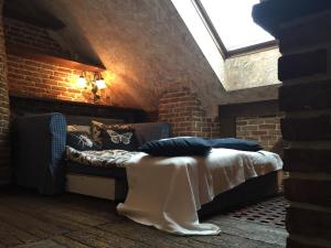 a room with a couch and a brick wall at Attic Apartment Warszawa in Warsaw