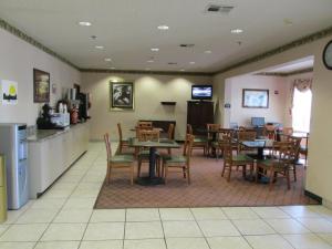 a restaurant with tables and chairs and a kitchen at Days Inn by Wyndham Jefferson City in Jefferson City