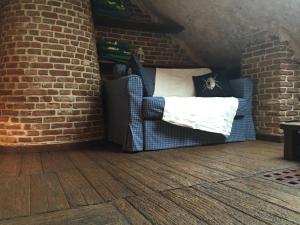 a living room with a couch and a brick wall at Attic Apartment Warszawa in Warsaw