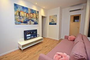 a living room with a couch and a flat screen tv at Apartman Michelangelo in the centar of Supetar in Supetar