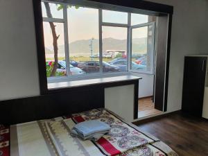 un letto in una camera con una grande finestra di Apartment Ada Kaleh a Orşova