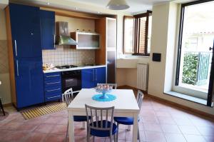 a kitchen with blue cabinets and a table with chairs at Residenza Ameca in Pizzo