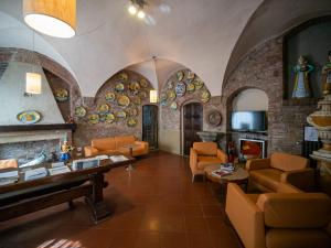 sala de estar con sillas de color naranja y pared de piedra. en Hotel Bel Soggiorno en San Gimignano