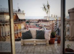 a couch on a balcony with a view of a city at Driade B&B in Milazzo