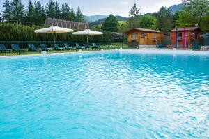 ein großer Pool mit Stühlen und Sonnenschirmen in der Unterkunft Hotel Iris in Pescasseroli