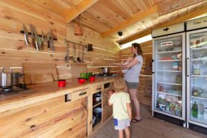 a woman and a child in a kitchen at Adrenaline Check Camping in Bovec