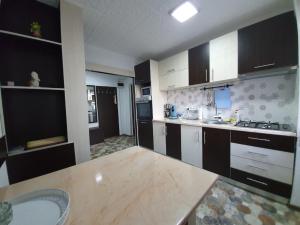 a kitchen with black and white cabinets and a sink at Apartment Ada Kaleh in Orşova